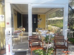 a restaurant with a patio with tables and chairs at Agriturismo La Collina Verde in Levanto