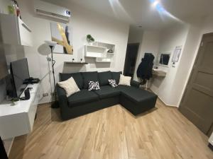 a living room with a black couch and white walls at Casa Manzoni in La Maddalena