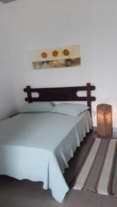 um quarto com uma cama branca e uma prateleira na parede em Casa do Ipê - Hospedagem em Lumiar