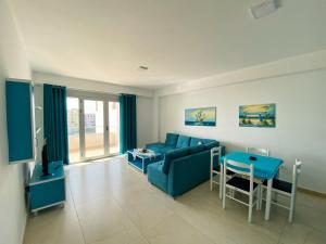 a living room with a blue couch and a table at Saranda Terraces Apartment Rentals in Sarandë