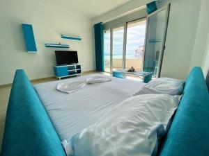 a large bed in a room with a large window at Saranda Terraces Apartment Rentals in Sarandë