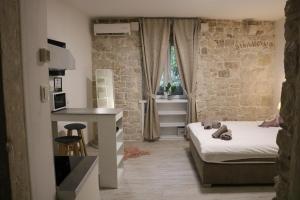 Posteľ alebo postele v izbe v ubytovaní Studios Kadena Trogir - 18th century stone house