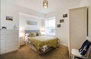 een slaapkamer met een bed, een dressoir en een raam bij The Bonting beautiful three bed townhouse near harbour and beach in Torquay