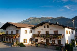 a large white building with mountains in the background at Gasthof Pension Traube in Karres