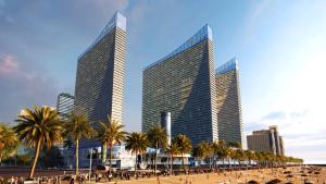 a group of tall buildings with palm trees and a beach at Blue Side Orbi City in Batumi