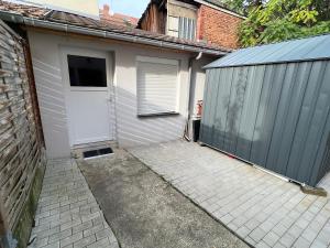 a garage with a white door and a fence at # Le 6 # Joli petit studio ! Centre ville au calme in Mulhouse