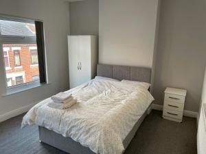 um quarto com uma cama, uma janela e uma cómoda em Modern House In Stoke on Trent em Stoke on Trent