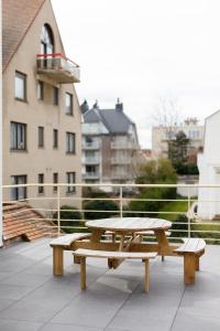 a picnic table on the roof of a building at Appartement - Vakantiehuis Manou in De Panne