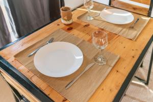 una mesa de madera con placas blancas y gafas. en Amwilla Guesthouse Apartamento Fátima en Mindelo