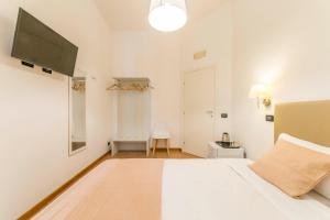 a bedroom with a white bed and a flat screen tv at I Mulini A Vento in Rome