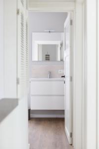 a bathroom with a sink and a mirror at Appartement - Vakantiehuis Manou in De Panne