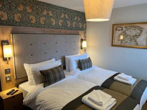 Dos camas en una habitación de hotel contigua en Queens Head Inn, Tirril, en Penrith