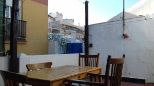y balcón con mesa y sillas de madera. en Malaga Ensuites City Centre, en Málaga