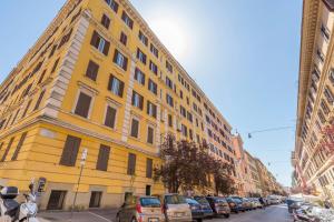 a yellow building on a city street with parked cars at I Mulini A Vento in Rome