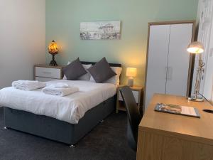 諾丁漢的住宿－P&J旅館，酒店客房配有一张床、一张书桌和一张书桌。