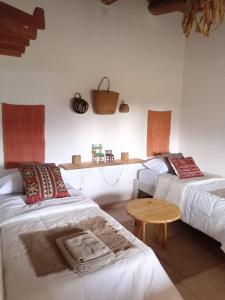 a room with two beds and a table in it at Casa Inkill Huasi in Tilcara