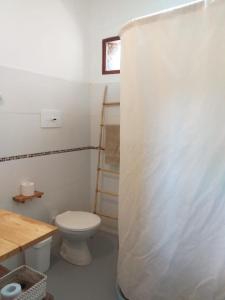 a bathroom with a toilet and a wooden table at Casa Inkill Huasi in Tilcara