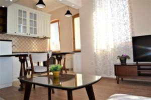 a living room with a table and a tv at Chola Guest House in Bitola