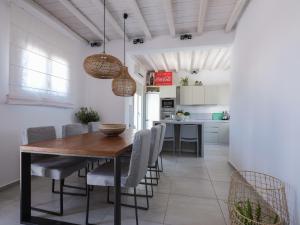 a kitchen and dining room with a wooden table and chairs at Secret Island in Tourlos