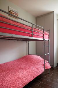 two bunk beds in a room with red sheets at Appartement - Vakantiehuis Manou in De Panne