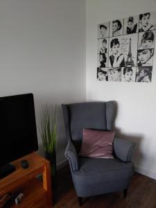 ein Wohnzimmer mit einem Stuhl und einem TV in der Unterkunft Madame Jacqueline - Steinhude in Wunstorf