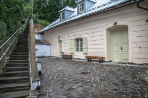 a building with a staircase and a door and benches at Apartmany pod schodami in Banská Štiavnica