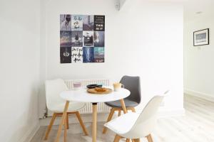 a dining room with a white table and chairs at Stylish, spacious flat with private parking in Bristol +2 photos