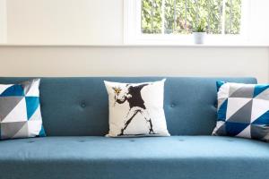 a cat pillow sitting on a blue couch at Stylish, spacious flat with private parking in Bristol