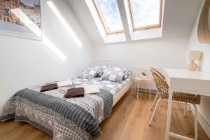 a bedroom with a bed and a desk and windows at Katowicka Premium Apartment in Kraków