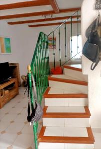 un escalier dans une maison avec une rampe verte et brune dans l'établissement Chalet en urbanizacion, à Dénia
