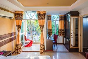 a living room with a large window with orange curtains at RIJ Hulhumale in Hulhumale