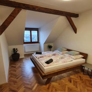 um quarto com uma cama grande num sótão em Prague Castle View Apartment em Praga