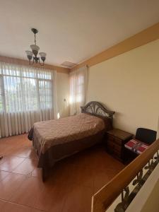 a bedroom with a large bed and a staircase at Casa con Piscina en Cochabamba in Cochabamba