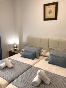 two beds in a room with blue and white pillows at Playa Honda vistas al mar, 1a Línea playa, PARKING, WIFI in Playa Honda