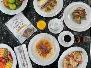 una tavola ricoperta di piatti di cibo e bevande di Hotel San Fernando Plaza a Medellín