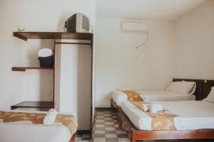 een kamer met 2 bedden en een dambord vloer bij Hotel Posada San Jose in San Pedro Pochutla