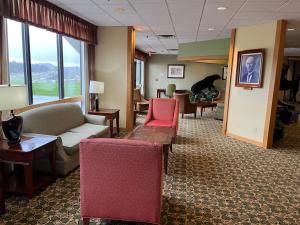 una sala de espera con sofás, sillas y ventanas en Days Inn & Suites by Wyndham Sutton Flatwoods en Sutton