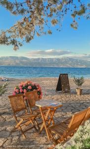 a picnic table and chairs on the beach at Kaya house in Nerežišće