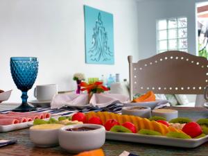 une table avec des assiettes de fruits au-dessus dans l'établissement La Maison de Vacances, à Búzios