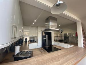 a kitchen with white cabinets and a black refrigerator at The Loft - Remarkable 2-Bed Anstruther Apartment in Anstruther