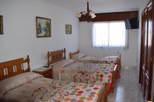 1 dormitorio con 2 camas y ventana en El Molino, en Melide