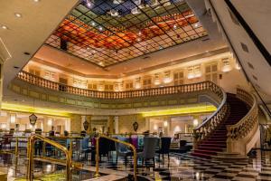 a restaurant with a staircase in a large building at Gamma Monterrey Gran Hotel Ancira in Monterrey