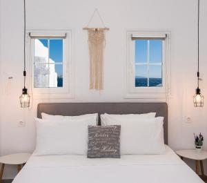 - une chambre avec un lit doté d'oreillers blancs et 2 fenêtres dans l'établissement Myconian Little Venice Elite Suites with Sea View, à Mykonos