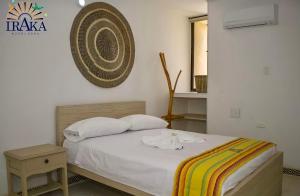 a bedroom with a bed and a fan on the wall at Hotel Iraka Zenu in Sincelejo