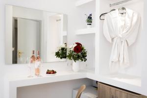 La salle de bains blanche est pourvue d'un lavabo et d'un miroir. dans l'établissement Myconian Little Venice Elite Suites with Sea View, à Mykonos