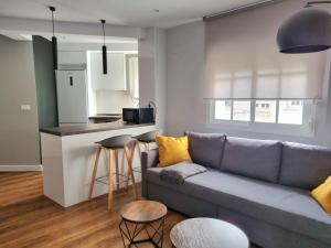 een woonkamer met een bank en een keuken bij Aujada playa in Cádiz +7 foto's