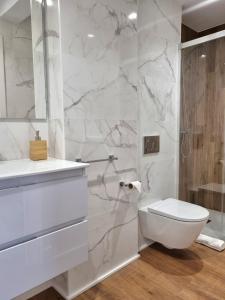 een witte badkamer met toilet en douche bij Aujada playa in Cádiz