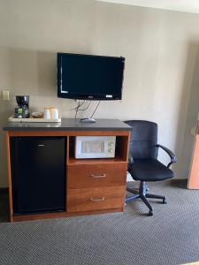 biurko z monitorem i krzesłem w pokoju w obiekcie Lone Pine Budget Inn w mieście Lone Pine