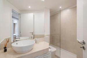 a white bathroom with a sink and a shower at The Boats Apartment by An Island Apart in Funchal +21 photos