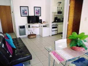 a living room with a black leather couch and a table at Depto En El Centro - Dean Funes in Córdoba